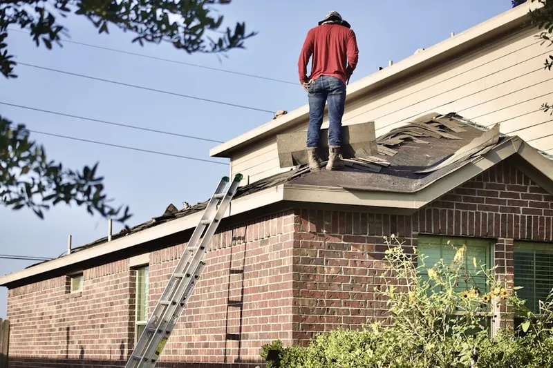 Professional roofer working on a residential roof in Creston